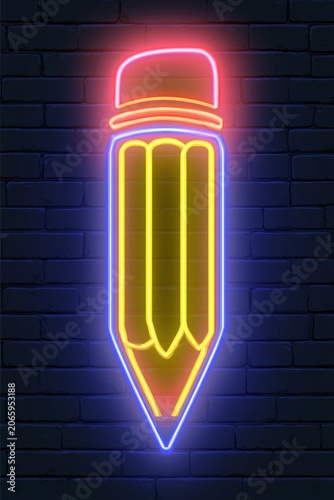 Neon pencil sign glowing bright on a dark background at night