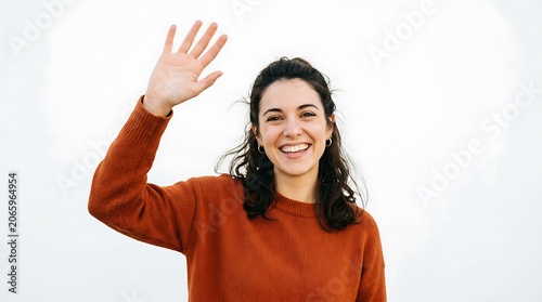 Woman in burnt orange sweater waving her hand isolated on white background