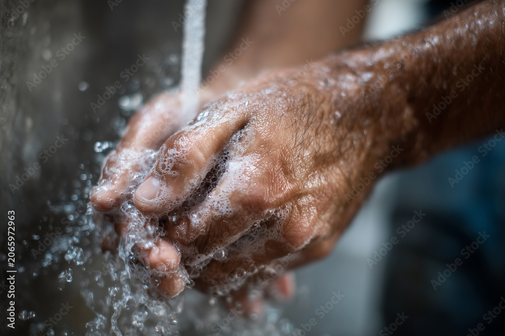 Fototapeta premium Water cascades over rough, weathered hands. Fingers twist under steady, cold stream. Skin shows age, dirt, and daily labor. Close-up captures clean, personal hygiene act. Ideal for health, wellness