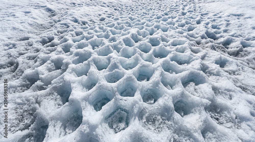Fototapeta premium Intricate Abstract Patterns Formed By Maze Of Small Sun Cups On White Glacier Ice Surface