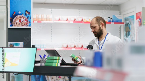 Bild auf Leinwand Healthcare workers arranging all pharmaceuticals on shelves, organizing medicaments or dietary supplements at pharmacy counter, two pharmacists checking and scanning all products and remedies
