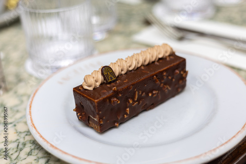 Принти на полотні Chocolate dessert served on a white plate in a dining setting with utensils in t