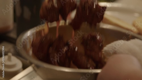 Slow motion chicken wings tossed in brown sauce bowl