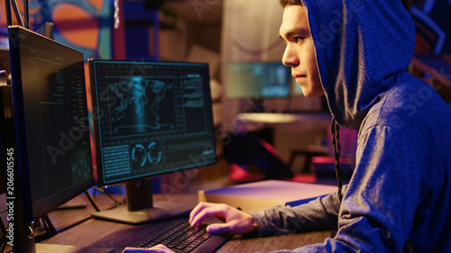 Fotografie Asian hacker doing international espionage warfare for his government to steal state secrets from another countries, anxiously looking over shoulder, afraid of being caught and going to jail