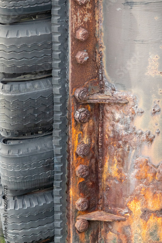 Close-up detail of a weathered marine fender system attached to a dock piling along a commercial waterfront in New Jersey.