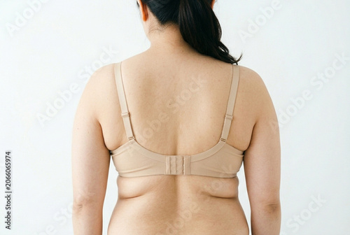 Fototapeta ブラジャーの食い込みによる背中のハミ肉と脇の脂肪、体型悩みの女性後ろ姿、補正下着・ダイエット・ボディケアを検討するイメージ