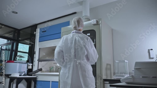 Professional Female Researcher Open Storage Cabinet In Science Laboratory