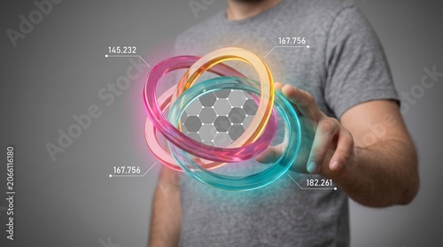Hand holding colorful glowing neon 3D rings against neutral background in futuristic digital style