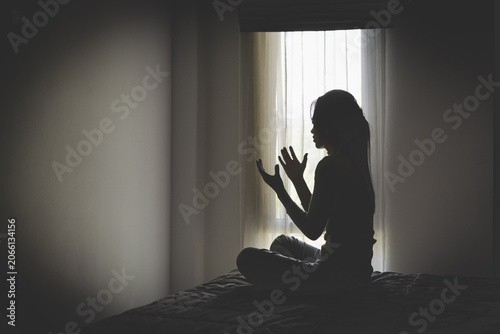 Quadro su tela A depressed woman kneels in prayer, seeking hope, healing, and strength through faith in God