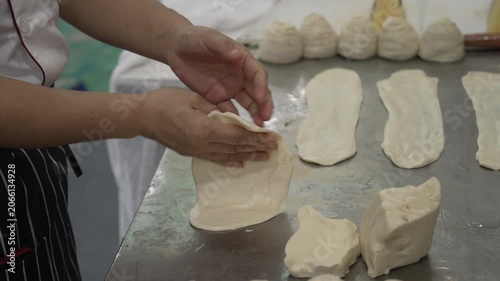 Hands of baker kneading dough on table