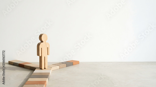 Mid-year performance review and career path decision concept with wooden figure standing at fork in the road with copy space for corporate employee evaluation presentation slide