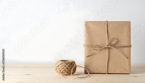 Neat roll of natural brown jute twine rope on textured light gray concrete background