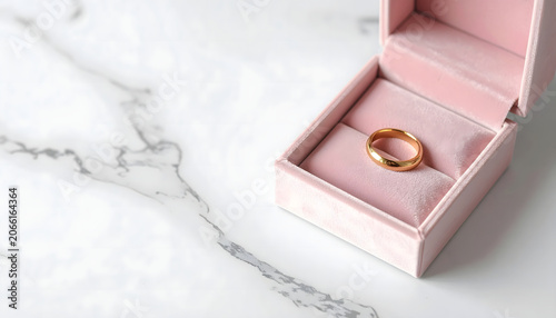 Elegant minimalist single gold band ring on warm neutral background with soft shadow