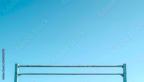 Minimalist low angle view of metal horizontal bars against clean blue sky background