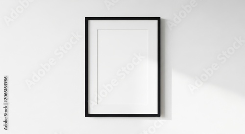 Modern black framed empty vertical poster mockup on white wall