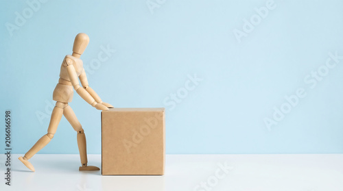 Employee assessment and business performance management concept featuring a wooden mannequin pushing a cardboard box with extensive copy space for a mid-year KPI review presentation.