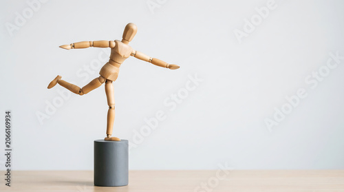 Work life balance performance evaluation concept with wooden mannequin balancing on cylinder with copy space for employee management presentation banner