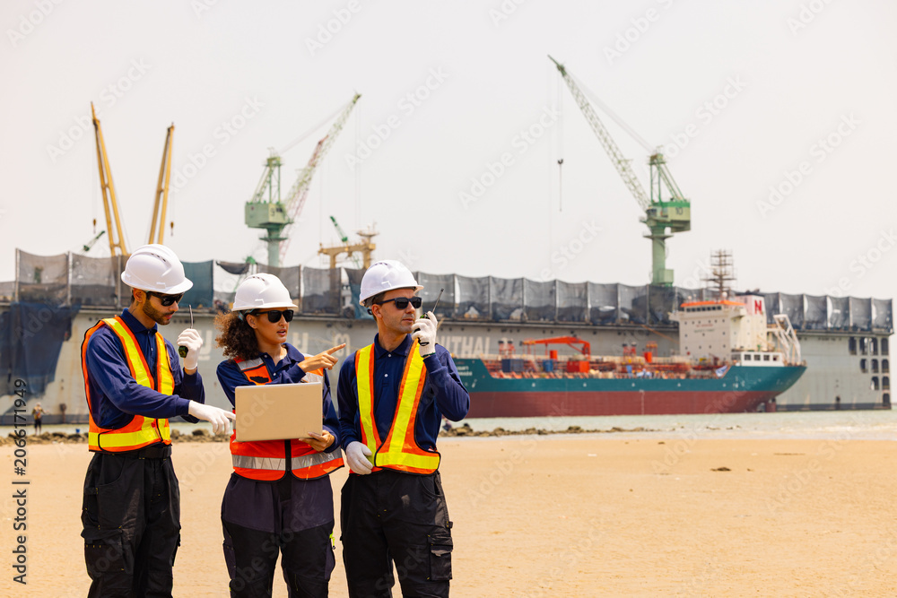 Fototapeta premium Engineers Reviewing Plans at Busy Shipping Port
