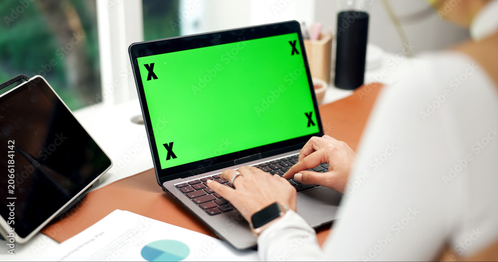 Fototapeta premium Laptop, green screen and hands in home for accounting, website and business research at desk. Remote work, mockup space and person with tech for typing budget, finance information and online review