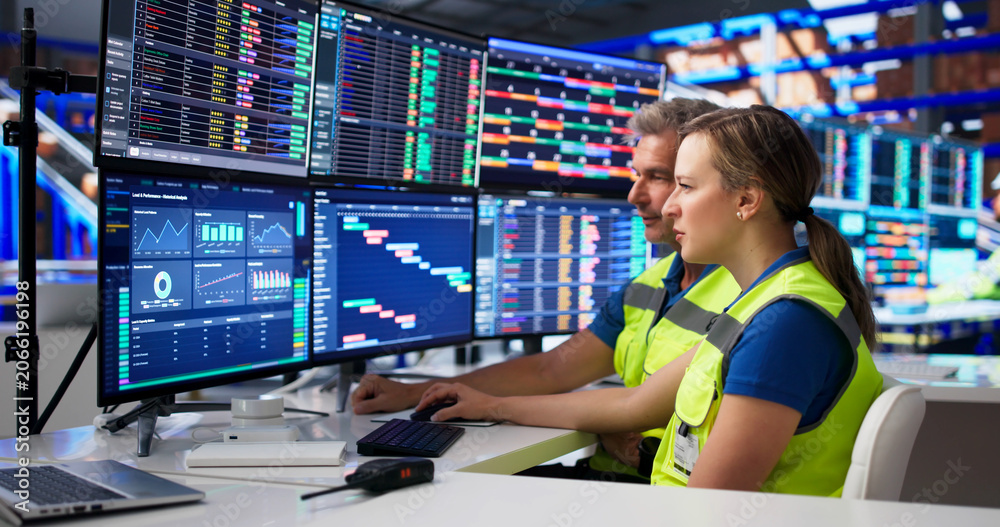 Naklejka premium Two Coworkers Studying Logistics Data On Computer Screens