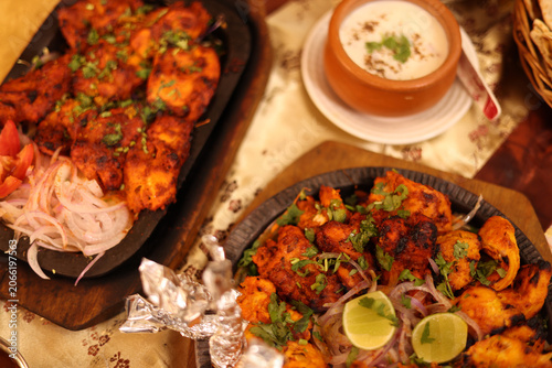 Fotografi Traditional Indian Tandoori Chicken Sizzler Platters with Yogurt Raita