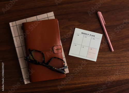 Leather cover notebook, to-do list, glasses on a wooden table, top view