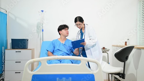Professional female doctor discussing medical chart with an Asian patient in a hospital bed.
