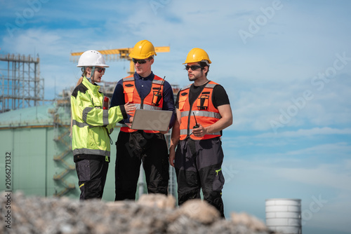 Construction worker team using laptop and walkie talkie for project planning outdoors