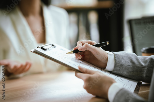 Canvastavla A confident businesswoman holding a resume during a job interview meeting in a modern office, discussing career opportunities with recruiters and HR professionals in a corporate hiring environment