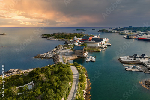 Tableau sur toile Aerial view of Svolvaer or Henningsvaer shows curved roads, docks, and red and white Nordic buildings on skerries, with marinas, a winding causeway, and calm Norwegian Sea