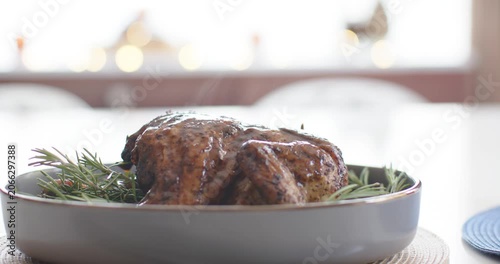Camera is pulling back, revealing glazed roast on oval dish by window as steam is rising