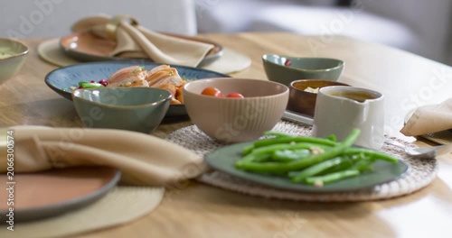 Camera is closing in and focusing on green beans at dining table, highlighting texture and garnish