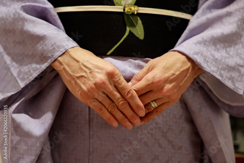 Close-Up of Elderly Woman's Hands Folded Over Traditional Japanese Kimono