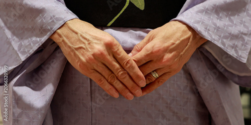 Close-Up of Elderly Woman's Hands Folded Over Traditional Japanese Kimono