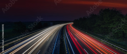 Bild auf Leinwand Highway light trails at night under dramatic dark red twilight sky  - authentic