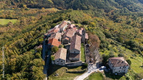 Aerial view of the historic stone houses and terracotta rooftops of the smallest town in the world, surrounded by autumn forests in Hum, Istria County, Croatia.
