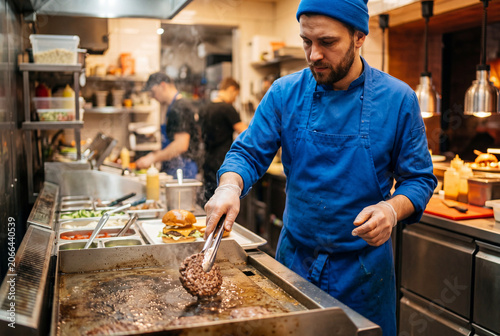 chef making cheese burgers in a kitchen