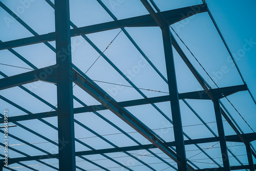 фотографія Metal beams crisscross against a clear blue sky