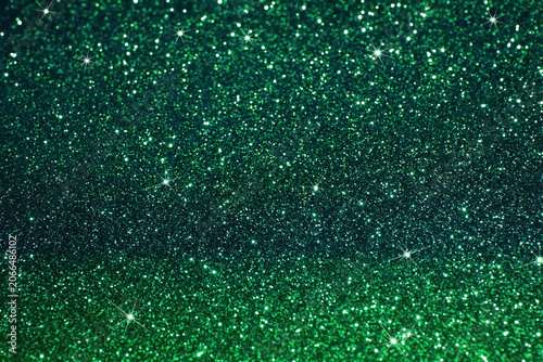 Shimmering green glitter background with sparkles for festive celebrations.