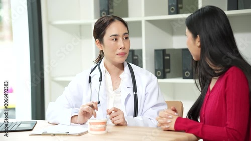 Professional dentist consulting with a patient in a modern dental clinic, explaining teeth restoration, prosthetic options, oral health care, treatment plans, and dental hygiene during a routine check