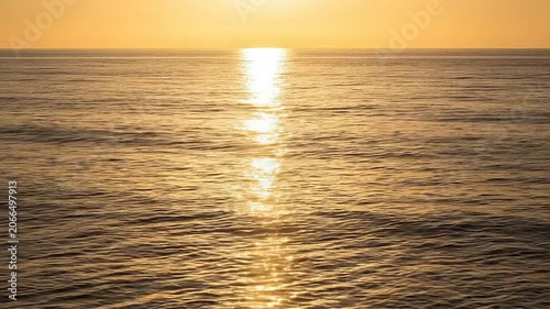 Golden sunset reflecting on calm ocean waves during a peaceful evening