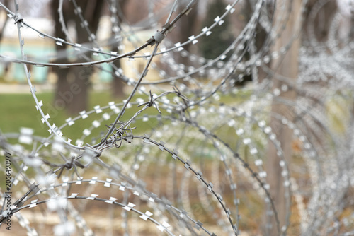Photos A sharp razor wire fence creates a formidable physical barrier against a blurred
