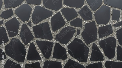 Top view of modern pavement made of irregular black stone slabs with white veins set in grey concrete terrazzo grout, abstract background texture