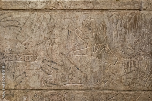 Billede på lærred Ancient Hand Carvings of Pilgrims on Stone Wall, Monte Sant Angelo, Italy