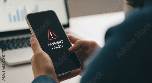 Person holding smartphone with payment failed message on screen in office
