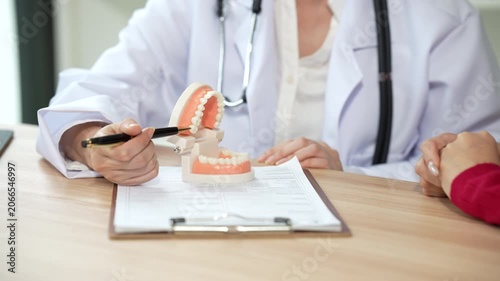 Professional dentist consulting with a patient in a modern dental clinic, explaining teeth restoration, prosthetic options, oral health care, treatment plans, and dental hygiene during a routine check