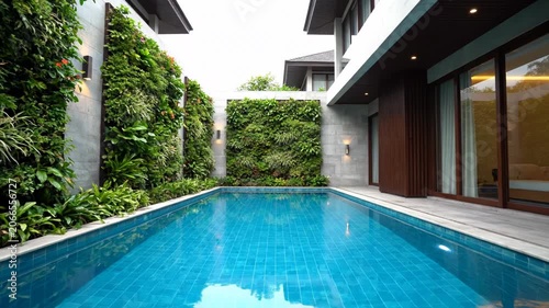 Modern luxury villa with private swimming pool and vertical garden walls.