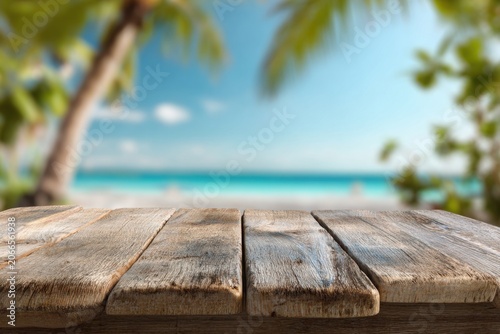 Empty Wooden Table with Tropical Beach and Palm Trees Background.