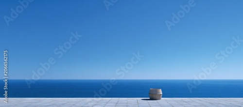 Minimalist seascape with a single stone against a clear blue sky and calm ocean horizon.