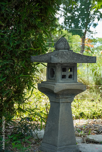 Konstfotografi Stone lantern in a tranquil garden setting with lush green bamboo foliage